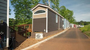 A row of mobile homes with a wooden deck and outdoor grill area. - Saddle (Anderson)