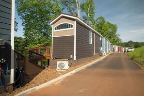 Eine Reihe von Mobilheimen mit Holzterrasse und Grillplatz im Freien.