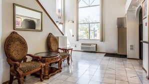 A spacious room with a dining table and chairs, a large window, and a refrigerator. - Econo Lodge Inn and Suites Albuquerque East I-40 Eubank Exit (Albuquerque)