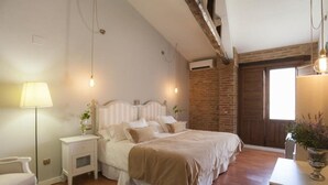 Ein Schlafzimmer mit einem Bett, Nachttischen, einer Lampe und einer Ziegelwand.