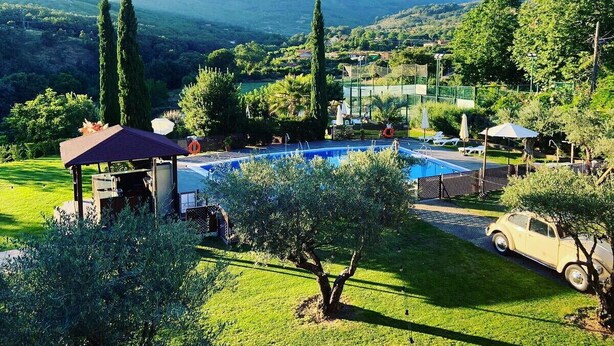 Ein Poolbereich mit Gazebo, einem Oldtimer und Blick auf die umliegende Landschaft.