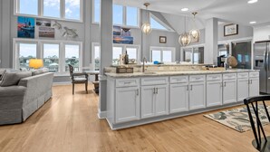 Una cucina spaziosa con ampie finestre, un'isola centrale e elettrodomestici moderni.