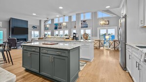 Cucina spaziosa con un'isola grande, elettrodomestici moderni e ampie finestre che offrono una vista.