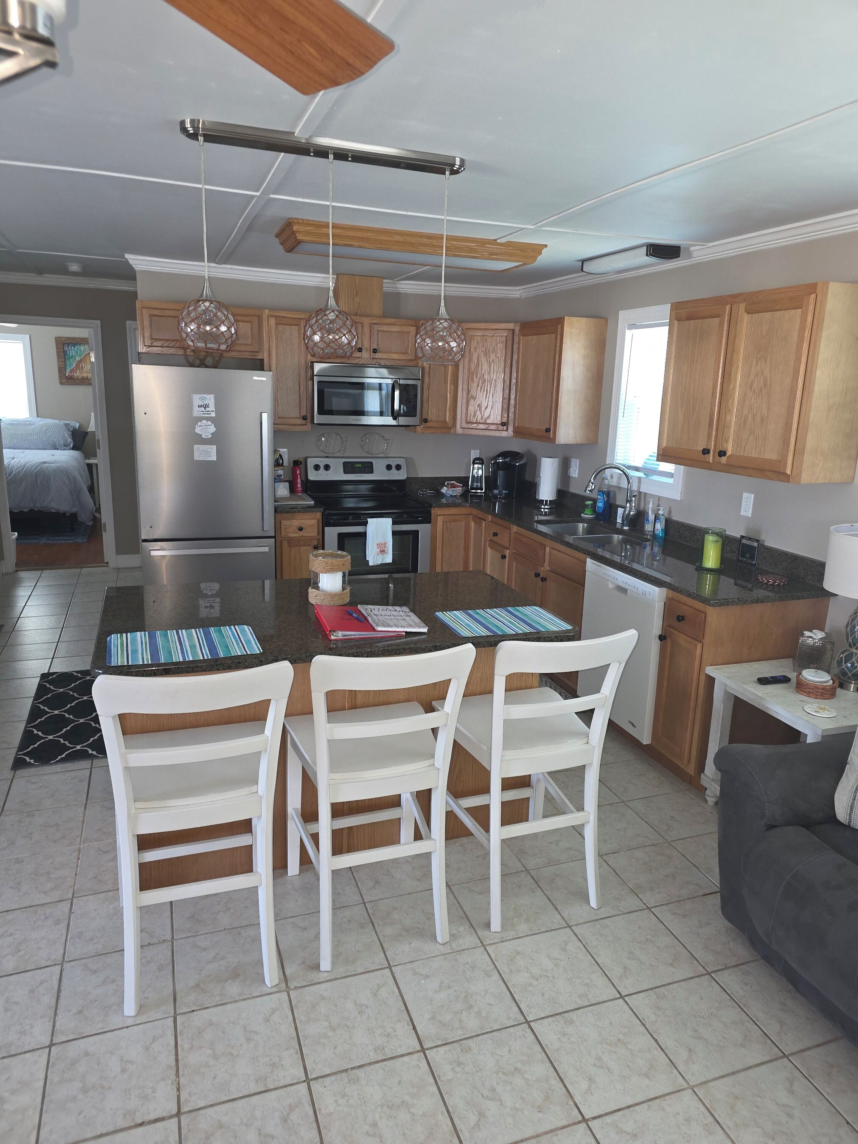A modern kitchen with wooden cabinets, stainless steel appliances, and pendant lighting.