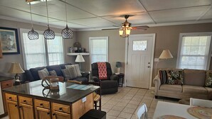 A spacious living area with a kitchen island, a dining table, and a sofa.