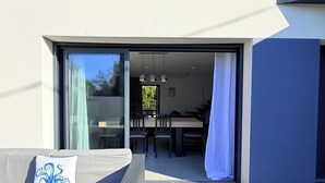 Un espacio al aire libre moderno con un sofá y una mesa de comedor.