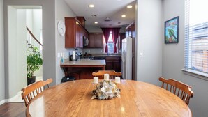 A dining area with a wooden table, four chairs, and a centerpiece.