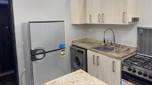 A compact kitchen with a refrigerator, washing machine, sink, and stove. - Two bedroom apartment with Swimming Pool in the Intercontinental area, Hurghada (Red Sea Governorate)