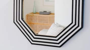 Ein wandmontierter, achteckiger Spiegel mit einem schwarz-weißen geometrischen Muster.