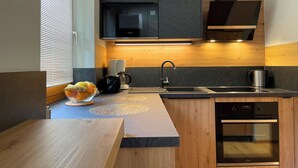 Une cuisine moderne équipée d’un four encastré, d’une machine à café et d’un évier.