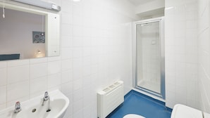 Een badkamer met een wit wastafel, toilet en douche.
