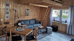 Un interno in legno con divano, tavolo e scala.