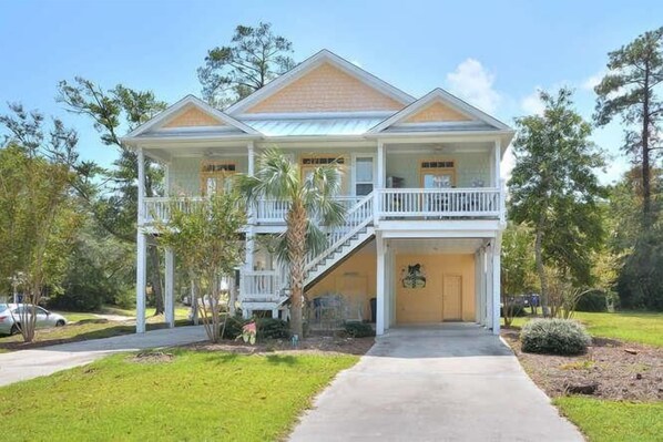 A two-story house with a balcony, a covered front porch, and a driveway.