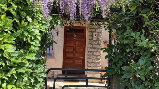A building with a stone facade, a wooden door, and a gate. - Villa glycines spacious 2 bedrooms close to town center enclosed garden dogs ok (Carcassonne)