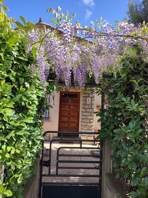 Un edificio con fachada de piedra, puerta de madera y un portón.