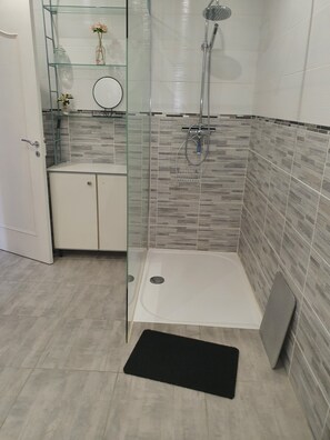 Regadera, secadora de cabello, toallas, papel de baño 