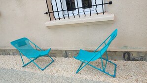 Two blue lounge chairs outside a building with a window and a small balcony. - Villa glycines spacious 2 bedrooms close to town center enclosed garden dogs ok (Carcassonne)