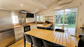 Eine moderne Küche mit einem Holztisch und -stühlen, einem eingebauten Backofen und einem großen Fenster.