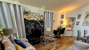 A living room with a sectional sofa, a coffee table, a fireplace, and artwork on the walls. - Spacious 6-bedroom Dorm Room lodge with AC in charming Los Angeles (Los Angeles)