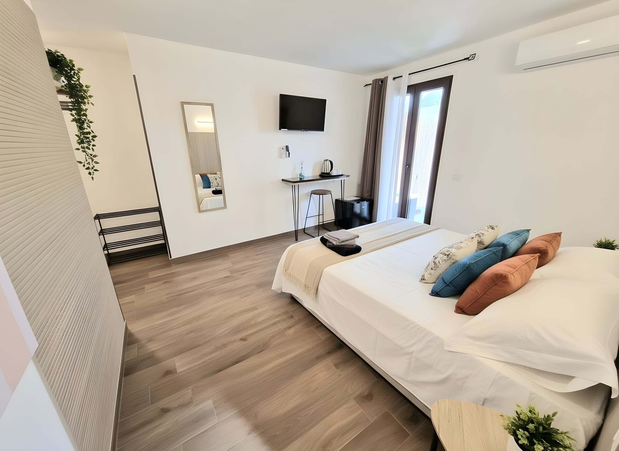 Une chambre d’hôtel moderne équipée d’un lit, d’un bureau, d’une télévision et d’une fenêtre avec des rideaux.
