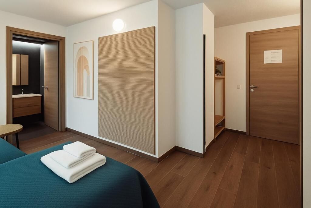 Ett hotellrum med en säng, ett badrum och en garderob.