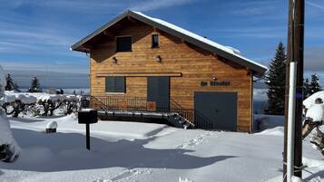 Une cabane en bois avec un toit en pente, une boîte aux lettres et une enseigne sur laquelle on peut lire « Au Bisolet ».
