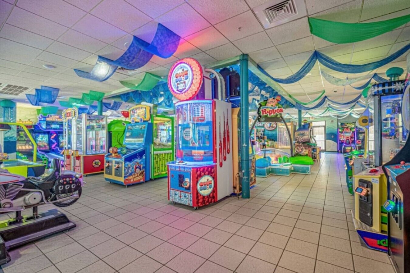 An indoor arcade with various gaming machines, including a prominent '300' game.