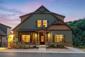 A two-story house with a front porch, a stone foundation, and a number '185' on the door. - Beautiful Views! Hot Tub! Ping Pong! (Branson)