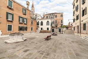 A courtyard with stone paving, benches, and historic buildings with arched windows and balconies. - 140 SQM APARTMENT A FEW STEPS FROM THE BIENNALE (Venice)