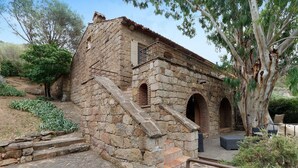 A stone building with a staircase leading to an upper level, a small balcony, and a tree in the foreground. - Holiday Home 'Missia' with Mountain View, Wi-Fi and Air Conditioning (Porto-Vecchio)