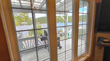 A room with large windows overlooking a deck area with outdoor furniture.