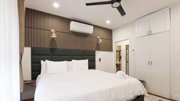 A bedroom with a bed, a ceiling fan, an air conditioning unit, and a wardrobe. - The Inn at Dupont (Washington)
