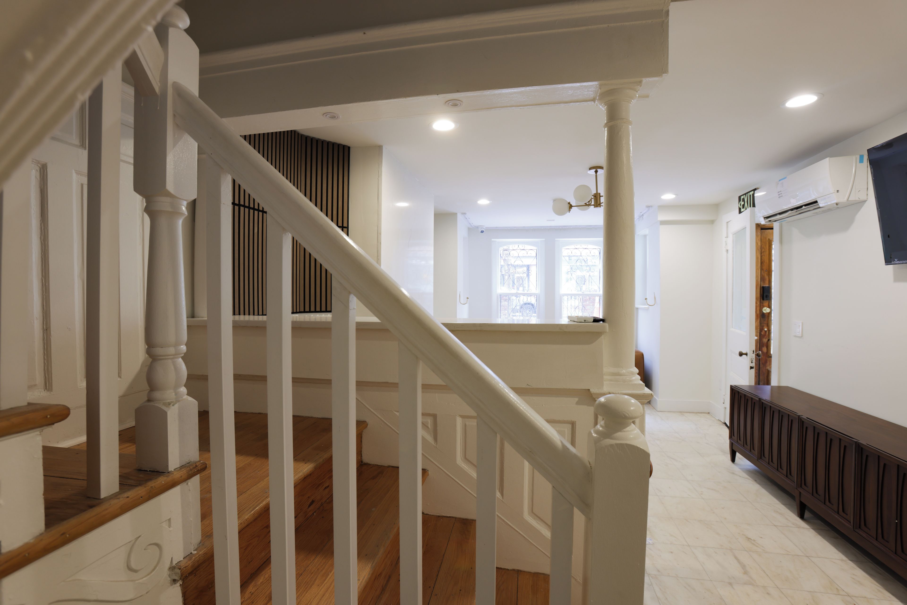 A staircase with white balusters leading to a landing with a view of a room.