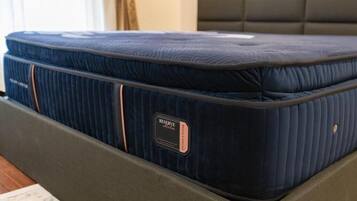 A bed with a dark blue mattress and a tag labeled 'RESERVE.'
