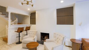 A modern living room with a fireplace, white furniture, and a staircase. - The Inn at Dupont (Washington)