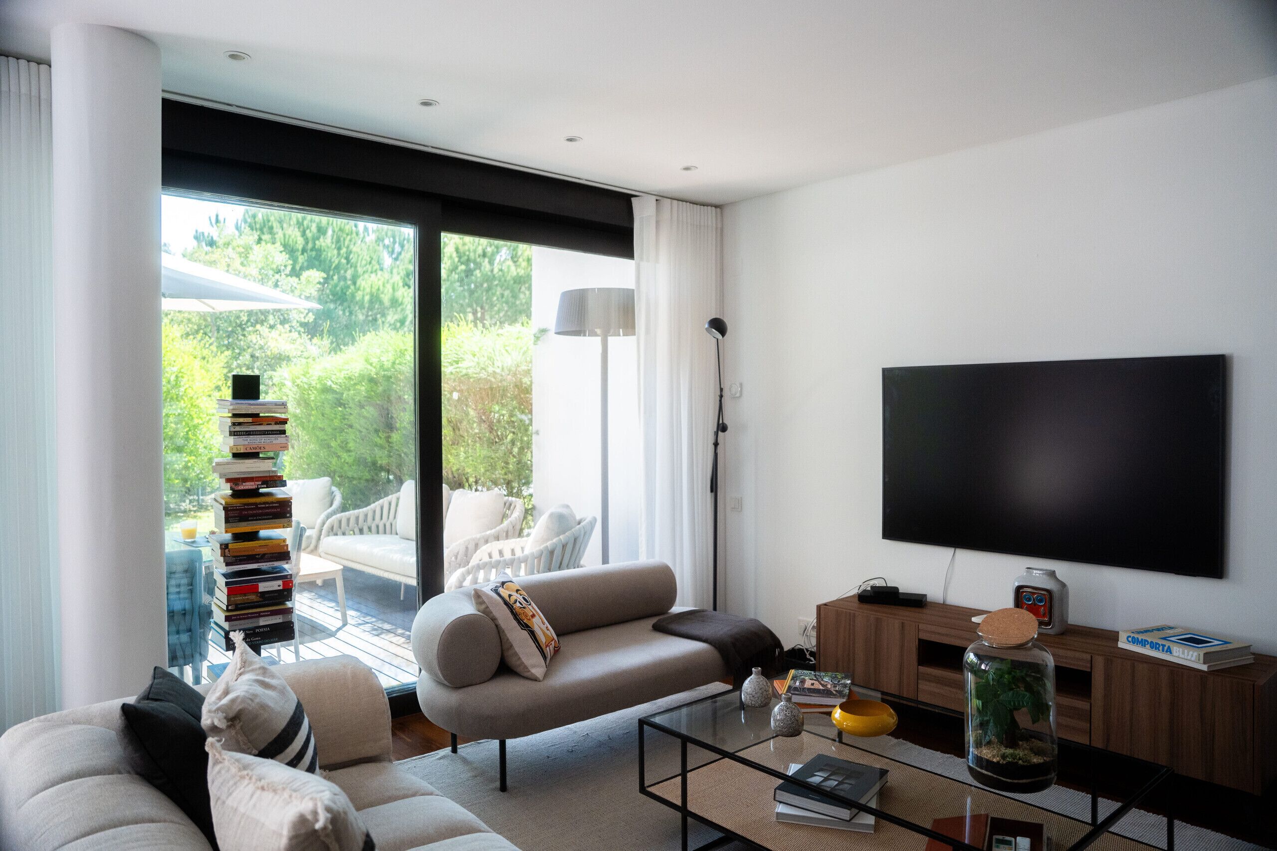 Un salon moderne avec un canapé, une table basse et un téléviseur.