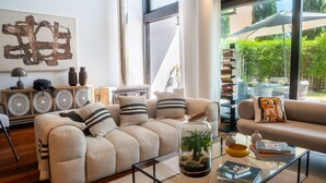 Ein modernes Wohnzimmer mit einer Couch, einem Couchtisch und einer Vitrine mit einer Pflanze.