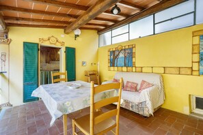 Una habitación con una mesa, sillas, un sofá tapizado, una ventana y una puerta.