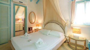 Una camera da letto con un letto, comodini, uno specchio e una finestra con tende.