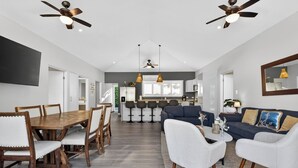 A spacious living area with a dining table, sofas, and a kitchen in the background. - Casa 17 at The Point // Playa Avellanas // 25 min to Tamarindo (Playa Avellanas)