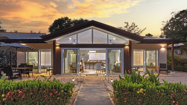 A modern house with a patio, a dining area, and a living room with a large glass door. - Casa 17 at The Point // Playa Avellanas // 25 min to Tamarindo (Playa Avellanas)