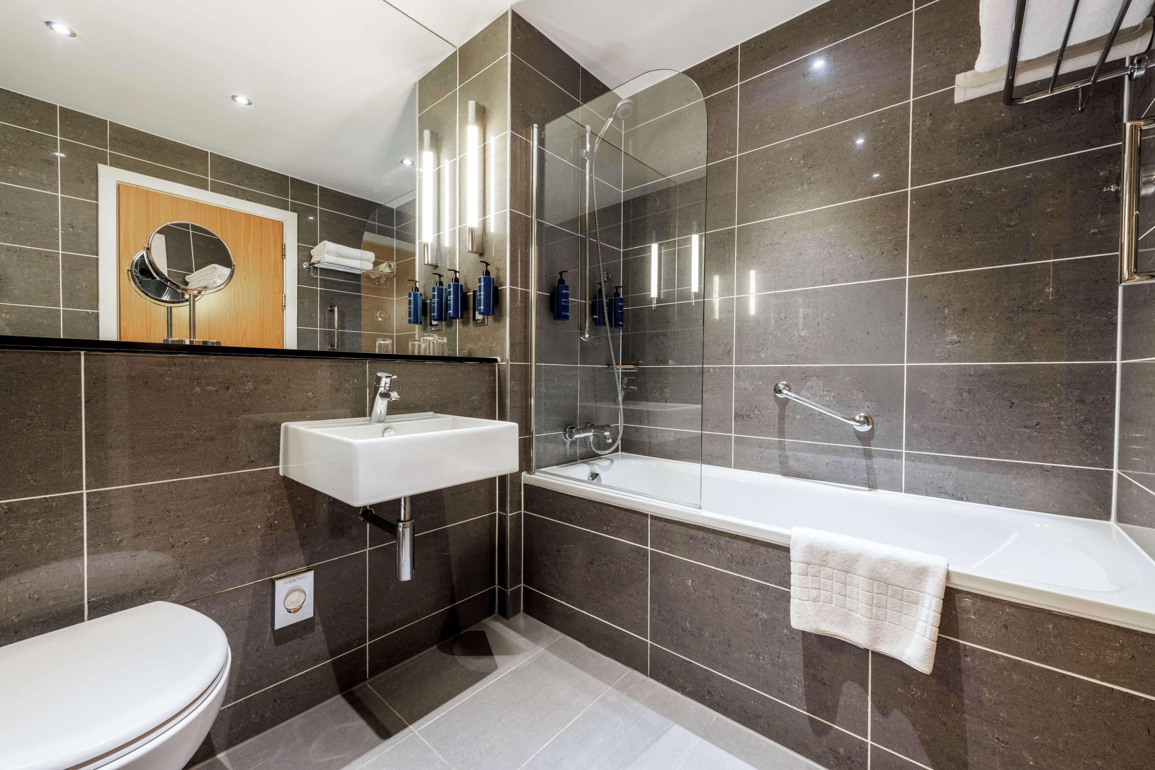 Un baño moderno con inodoro, lavamanos y bañera.
