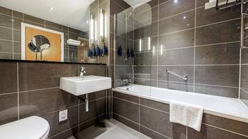 Un baño moderno con inodoro, lavamanos y bañera.