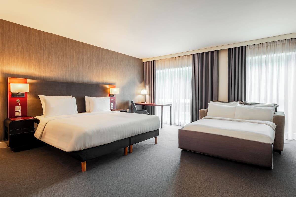 Een hotelkamer met twee bedden, een bureau en een stoel.