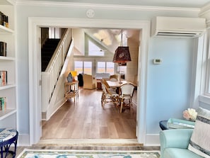 Ein geräumiger Wohnbereich mit Treppe, Esstisch und Stühlen, der zu einem Balkon mit Aussicht führt.
