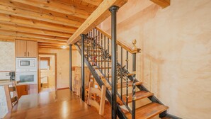 A wooden staircase with black railings leading to an upper floor. - Rural House 'Peña' with Mountain Views, Shared Pool and Wi-Fi (Castro de Fuentidueña)