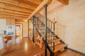 A wooden staircase with black railings leading to an upper floor. - Rural House 'Peña' with Mountain Views, Shared Pool and Wi-Fi (Castro de Fuentidueña)