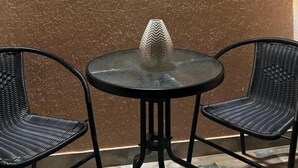 A small round table with a glass top and a decorative vase, flanked by two wicker chairs. - Hotel sataplia (Tsqaltubo)
