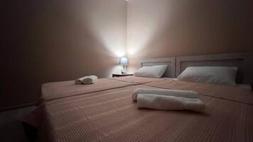 Een hotelkamer met twee bedden, een nachtkastje met een lamp en een dakraam.