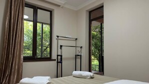 A hotel room with a bed, two towels, a window, and a door leading to a balcony. - Hotel sataplia (Tsqaltubo)